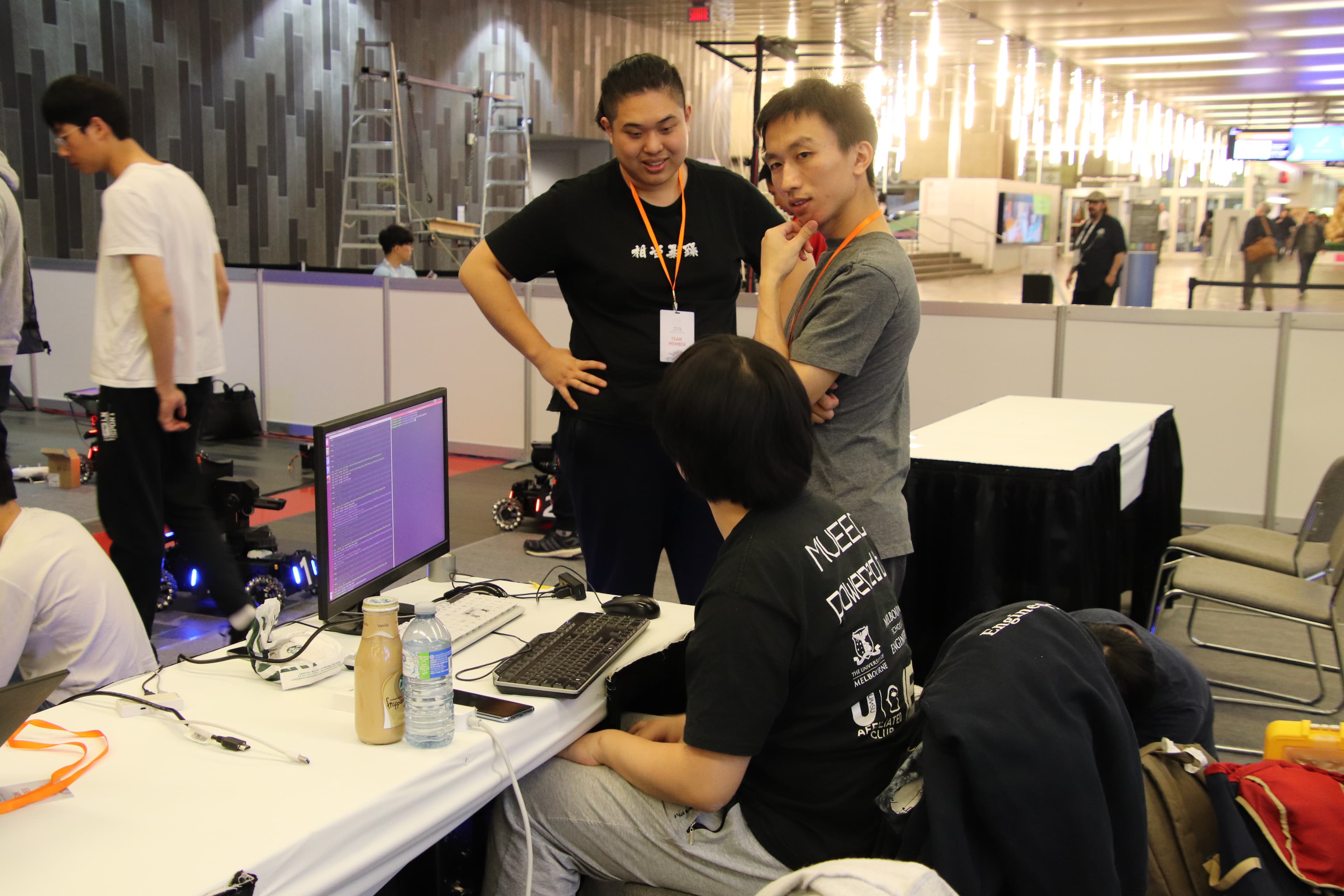 Team members preparing their robots and software at the competition venue