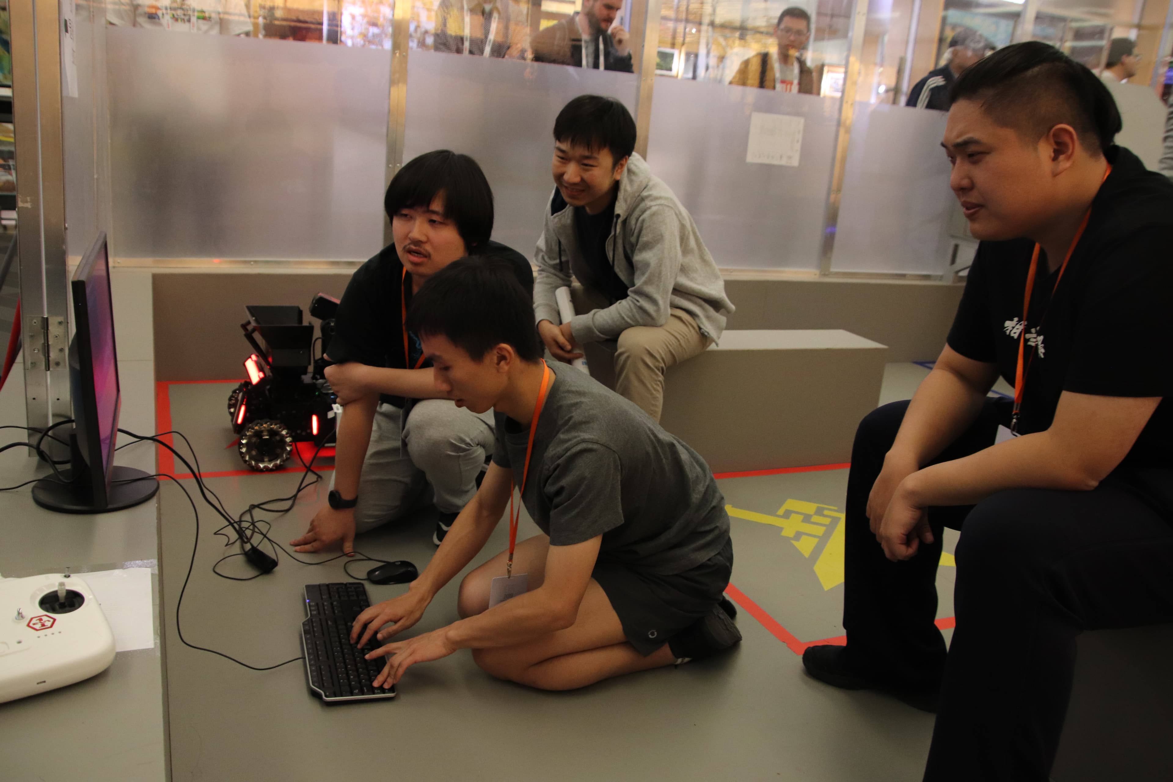 Team members testing a robot beside the competition field