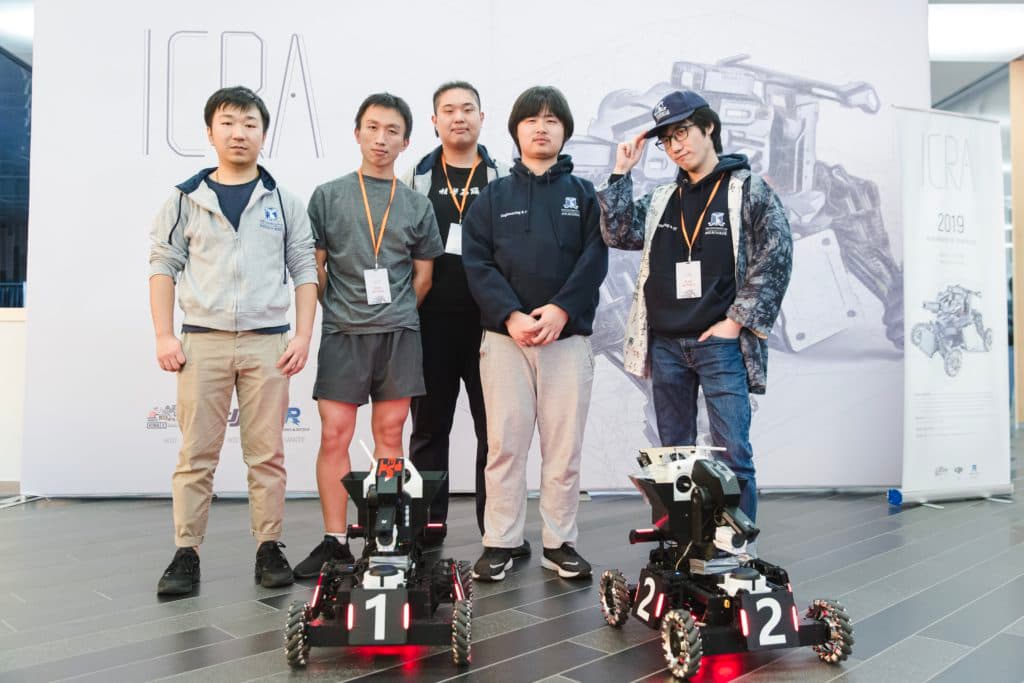 Ausdroid team members with two robots at ICRA 2019