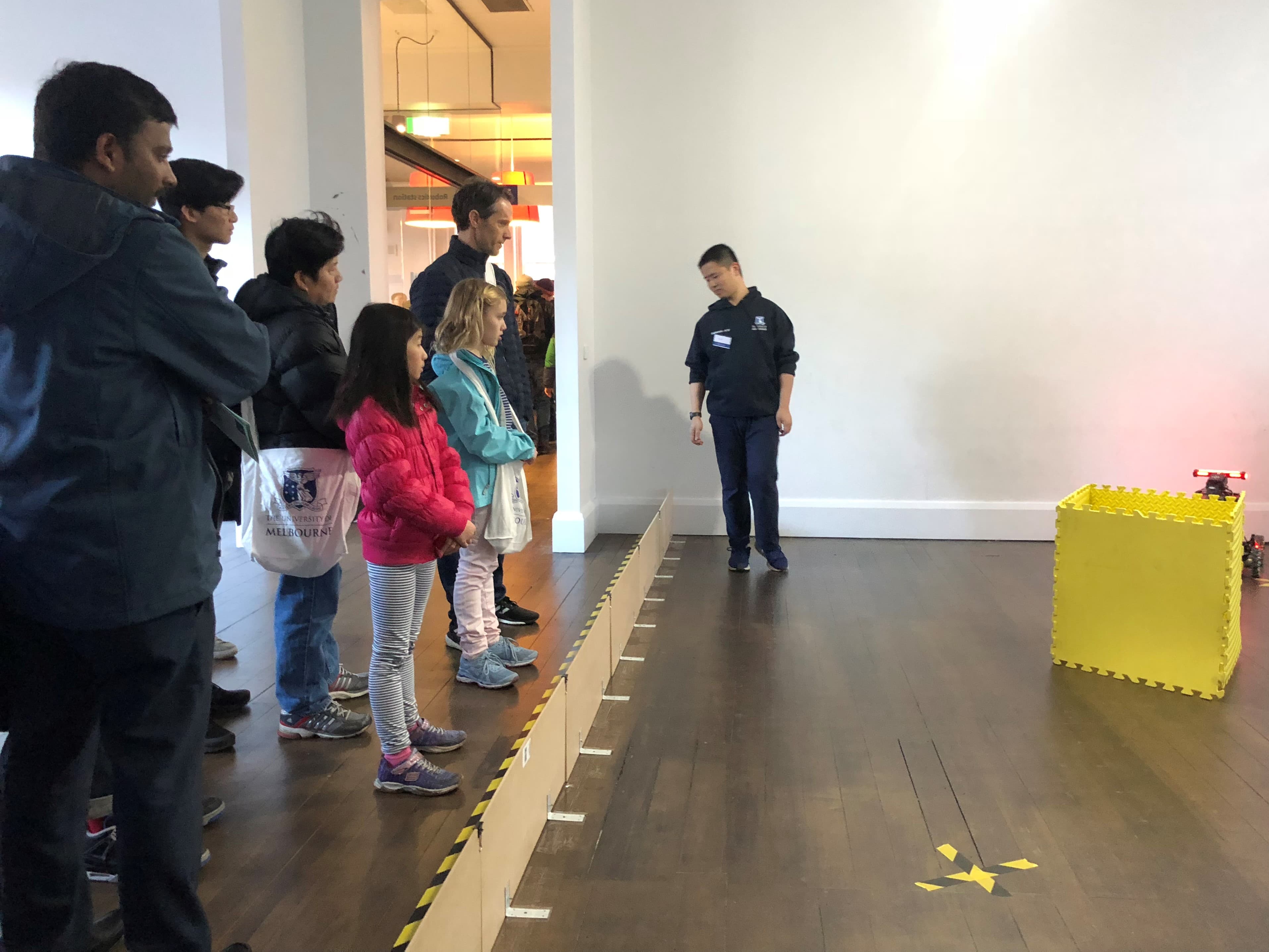 Families watching the robot at the Ausdroid display