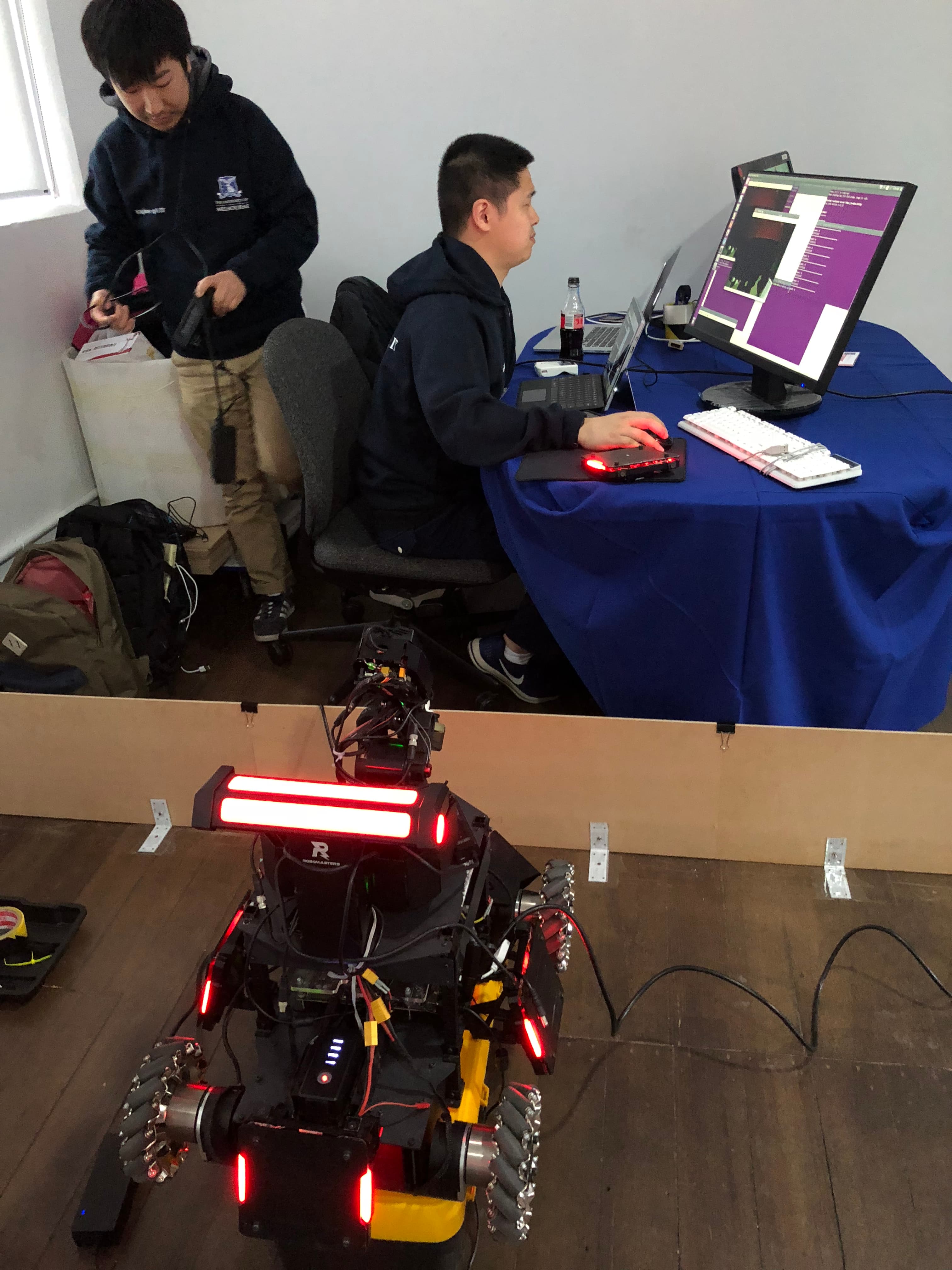 Volunteers working at a computer beside the robot
