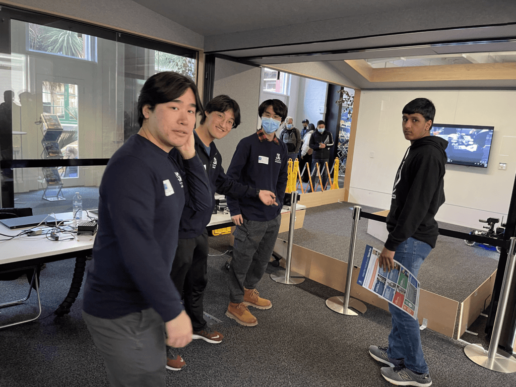 Ausdroid volunteers and a visitor beside the robotics display at Open Day 2021