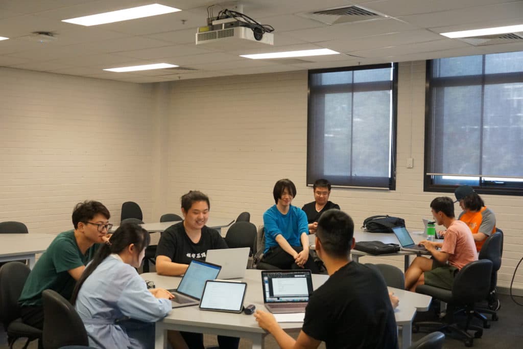 Workshop participants working together around tables with laptops